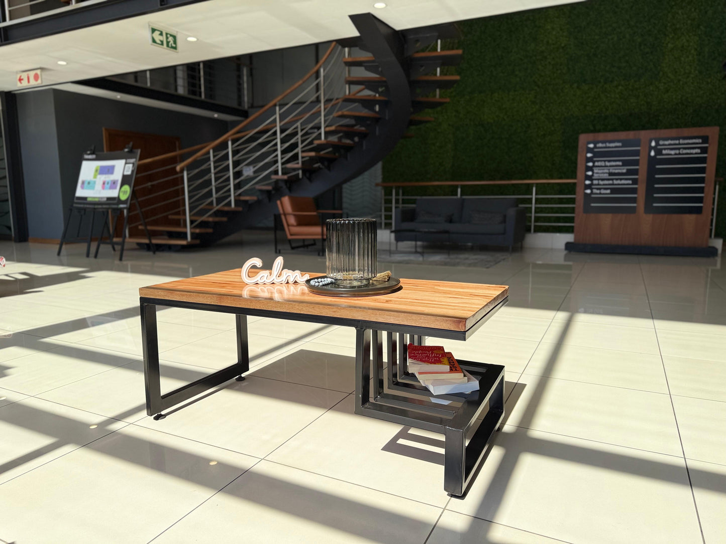 Modern office interior with a wooden coffee table and decorative items.
