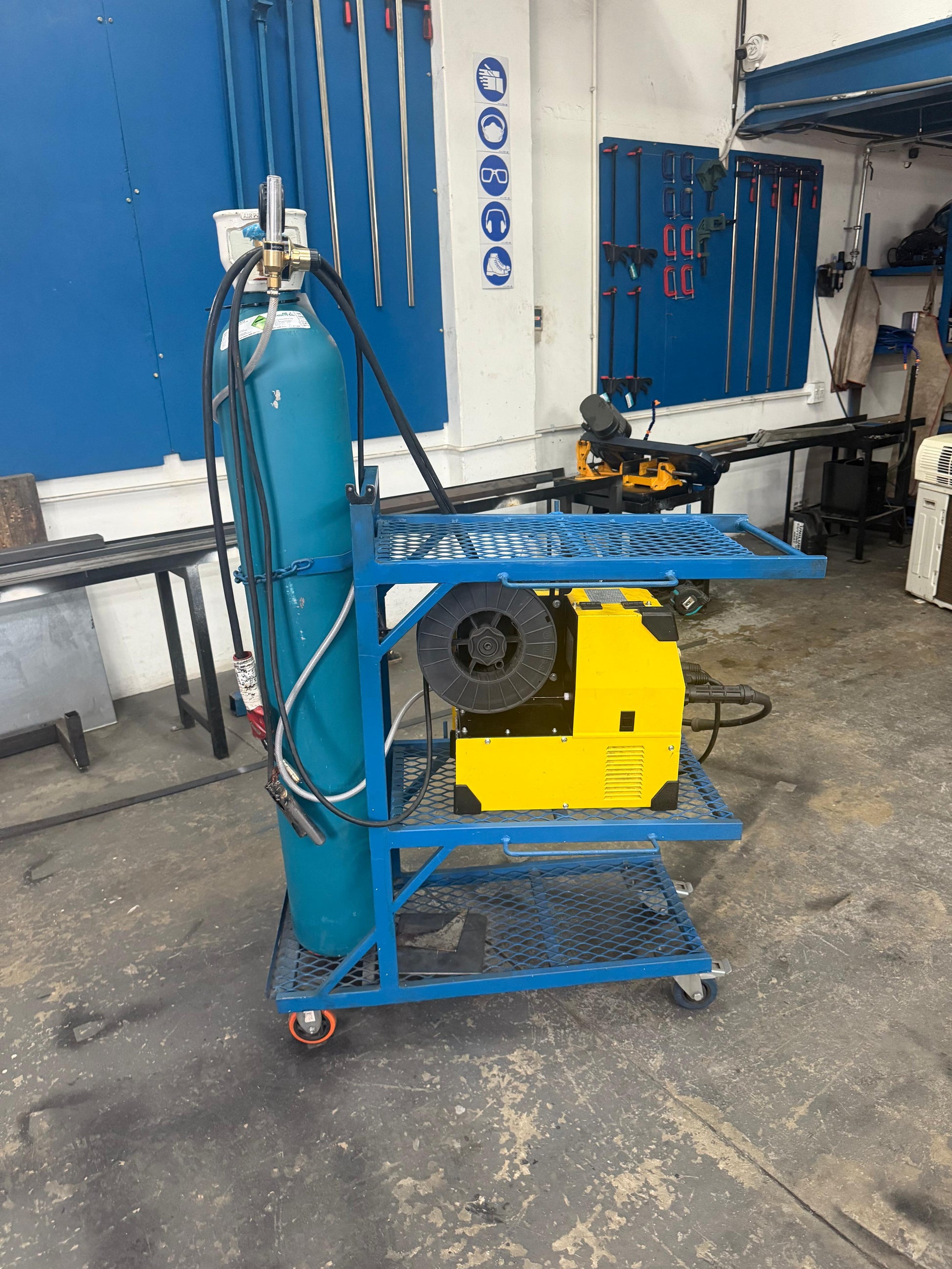 Welding machine and gas cylinder on a cart in a workshop setting
