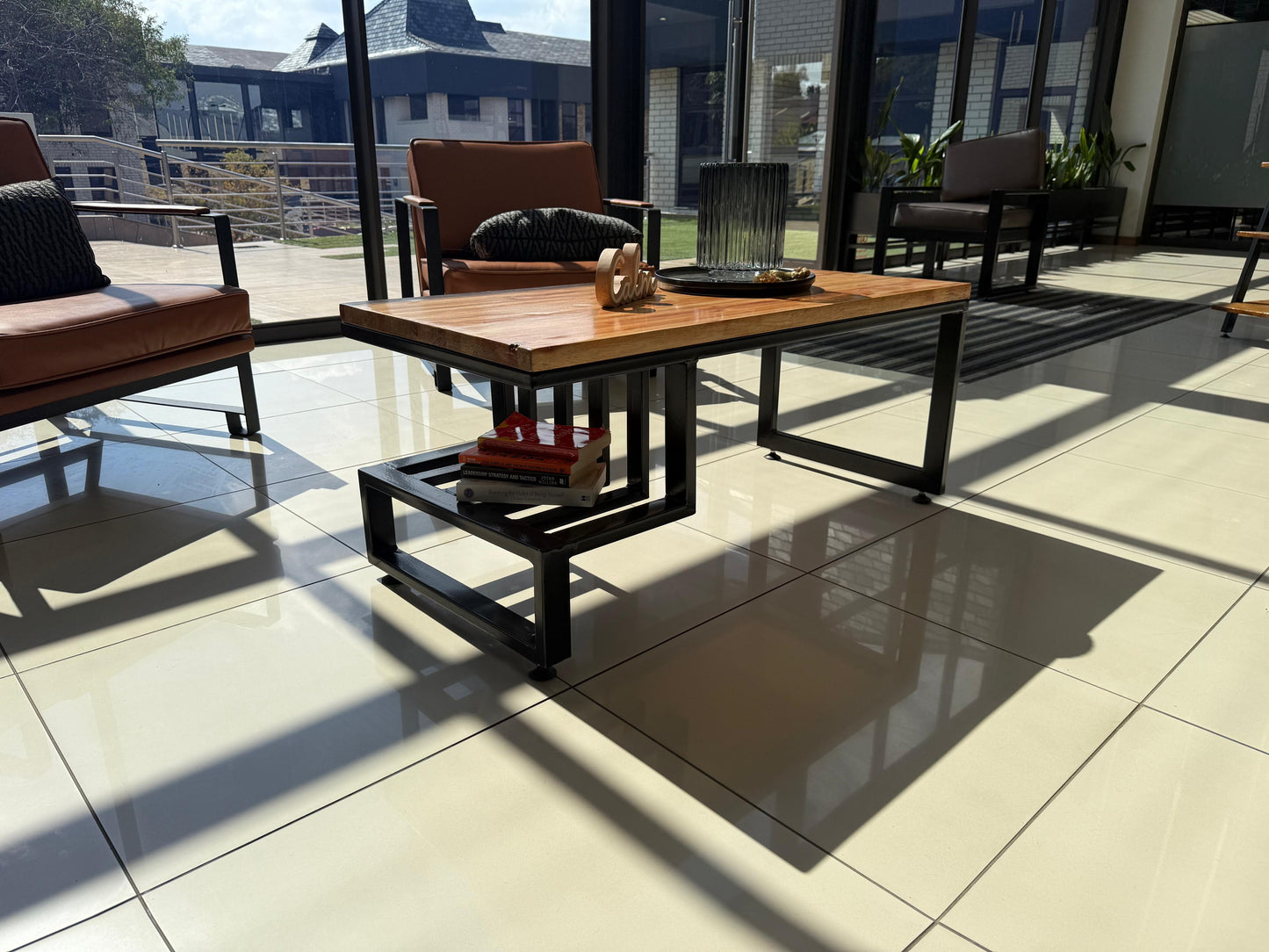 Outdoor patio setting with a wooden coffee table and chairs on a tiled floor.