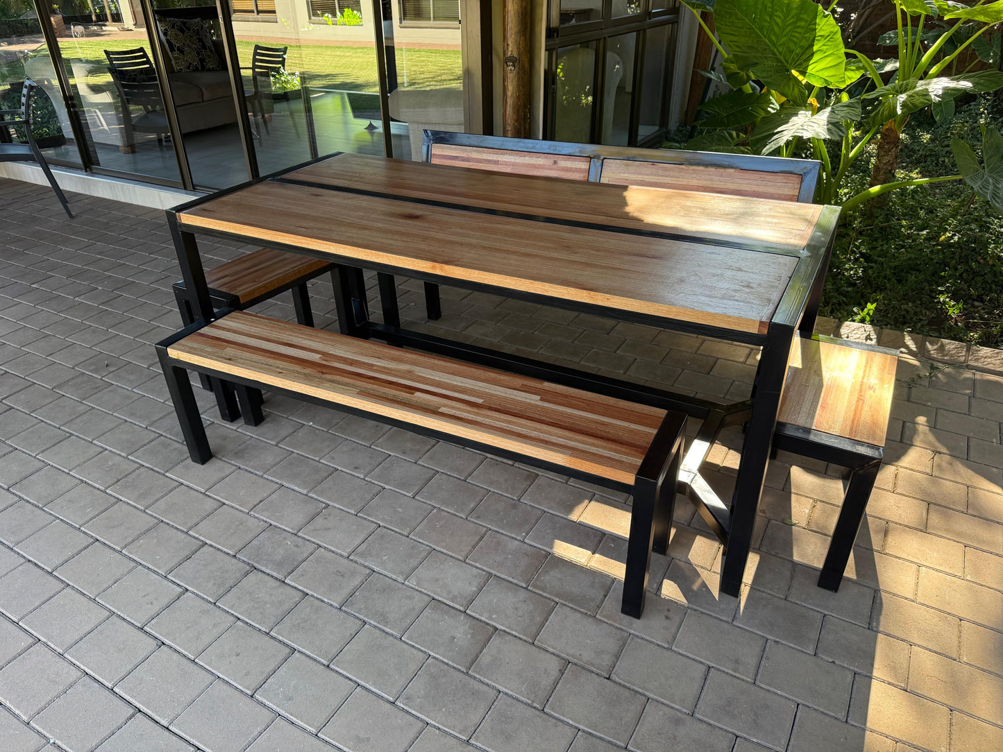 Wooden outdoor table with benches on a paved patio
