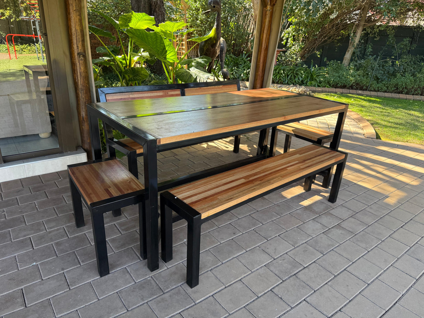 Outdoor dining table with benches on a paved patio